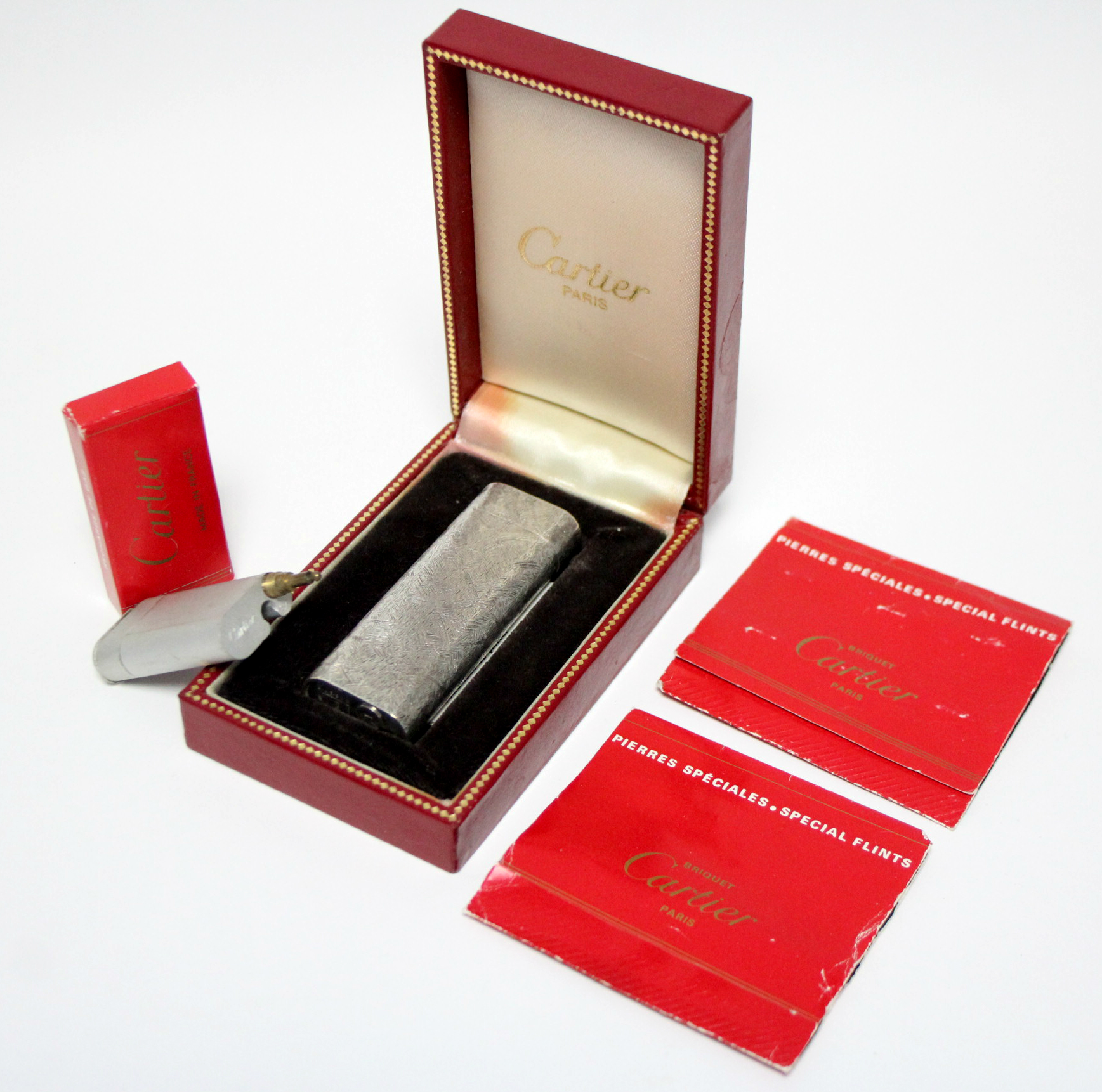 A Cartier pocket cigarette lighter in white metal “Brushed Florentine” case; in original box, with