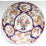 A late 19th century Japanese Imari charger painted with floral panels; 18” diam.