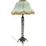 An unusual Chines bronze table lamp with tall narrow cylindrical pierced scroll-work column on three