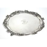 An Edwardian salver with raised & pierced scroll border, engraved family crest to centre, & on three