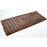 A modern Persian rug of ivory ground with all-over repeating multi-coloured geometric pattern; 6’ 2”