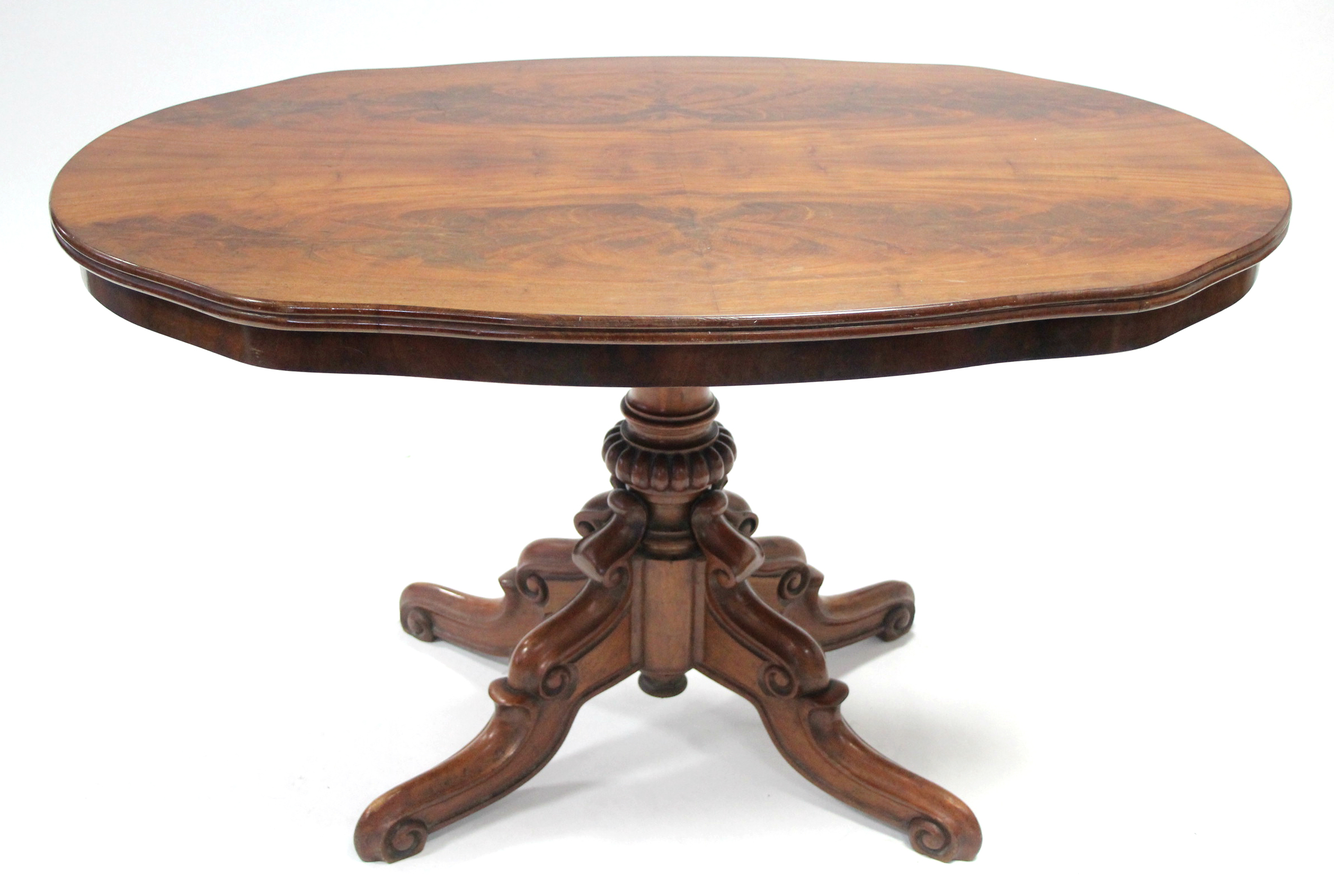 A late Victorian mahogany breakfast table, the shaped oval top on central turned & fluted column, on