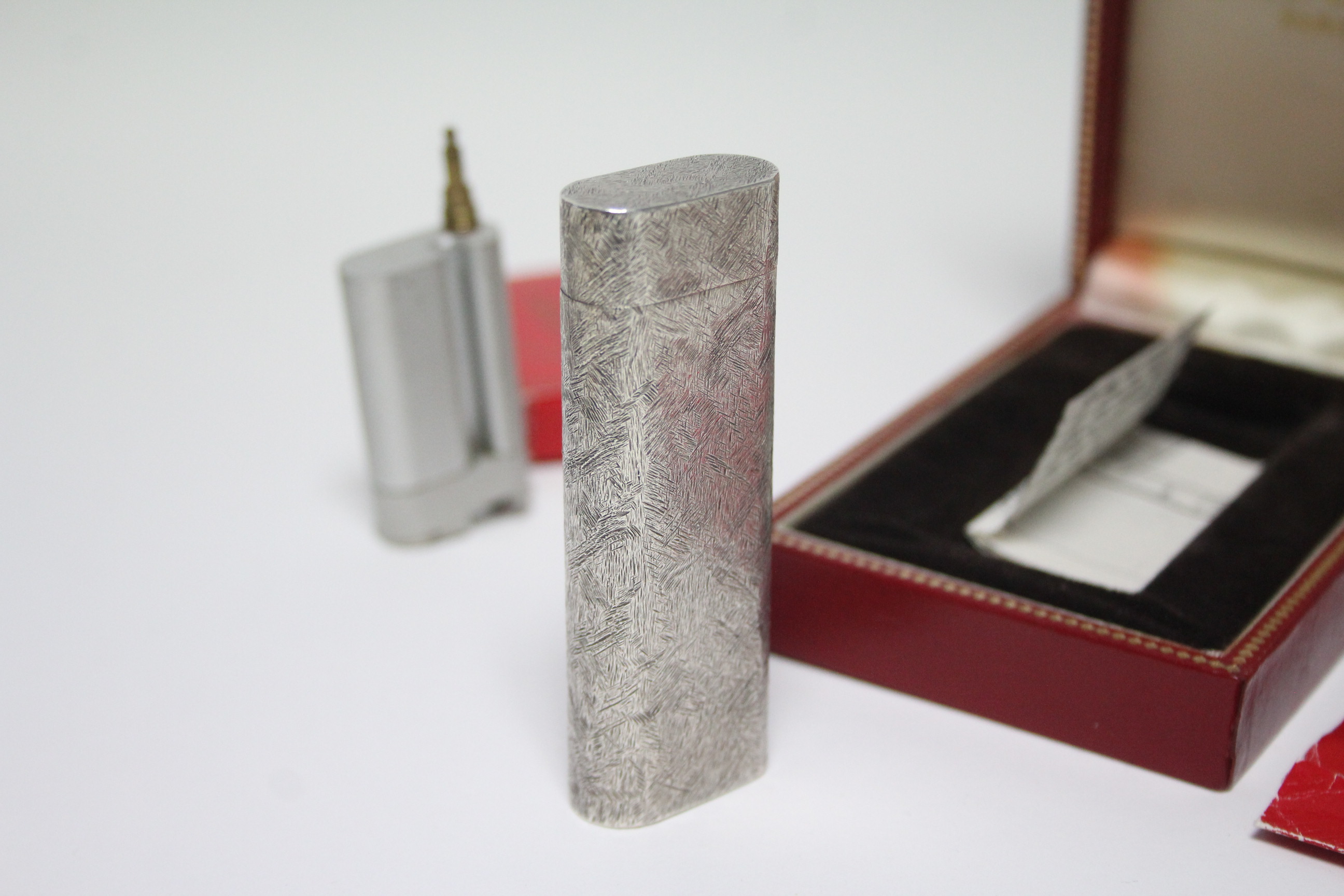 A Cartier pocket cigarette lighter in white metal “Brushed Florentine” case; in original box, with - Image 3 of 4