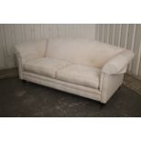 A Victorian-style three seater settee upholstered cream material, & on short turned legs with