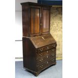 A late 18th century oak bureau-bookcase with adjustable shelves enclosed by a pair of panel doors,