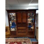 A late 19th/early 20th century mahogany combination wardrobe with blind fret-work cornice, with