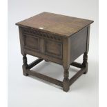 A reproduction carved oak storage box with hinged lift-lid, & on turned supports with plain