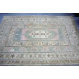 A Turkish carpet of ivory & pink ground with multi-coloured geometric design to centre within a