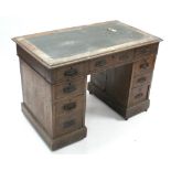 A Victorian oak small pedestal desk fitted with an arrangement of nine drawers (slight faults),