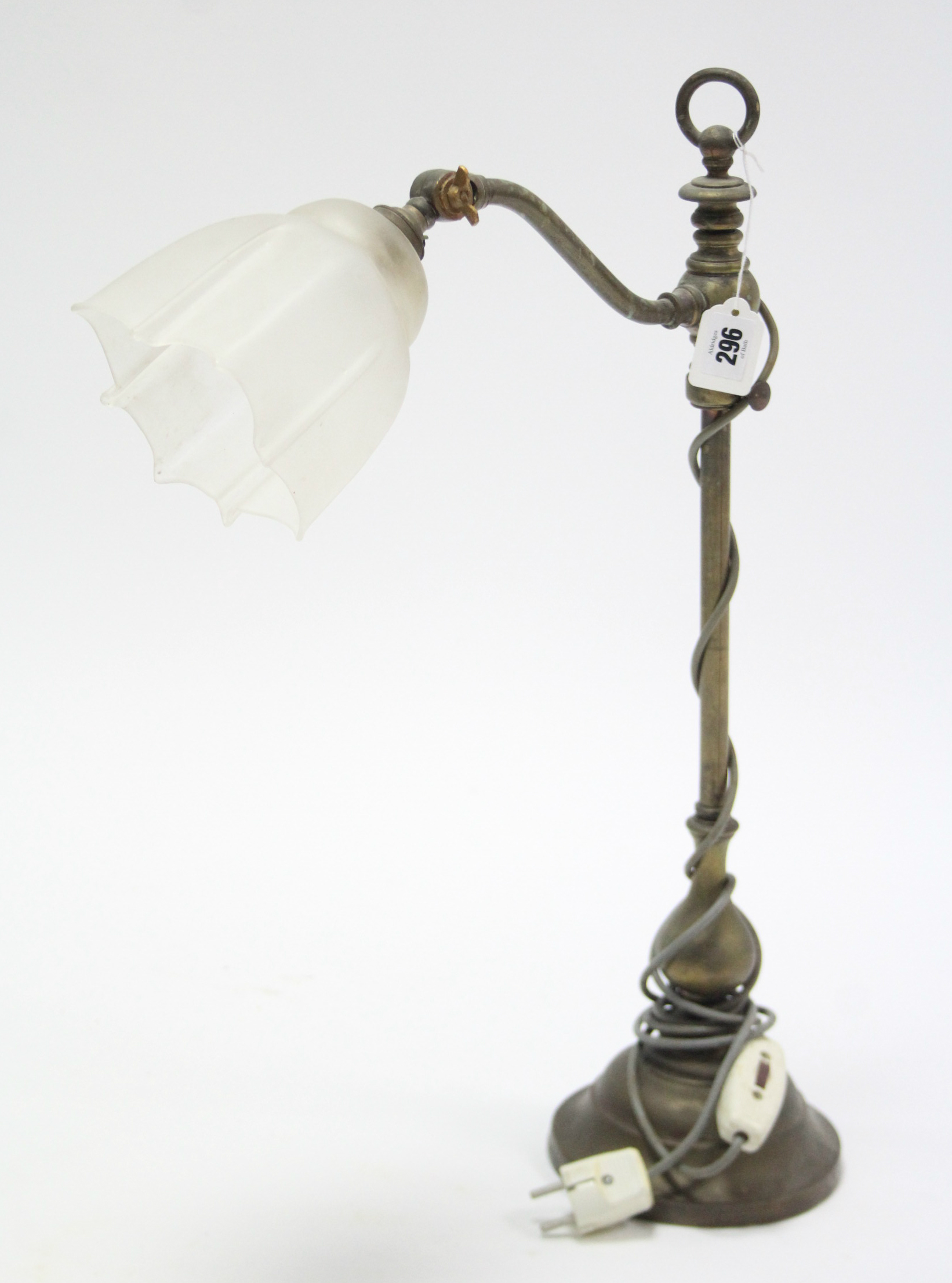 An Edwardian brass table lamp with glass shade to the single scroll-arm, revolving centre column &on