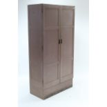 A mid-20th century painted wood tall office cabinet enclosed by pair of panelled doors, with