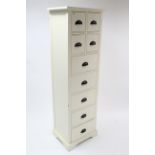 A white-finish tall narrow upright chest fitted with an arrangement of four short & five long