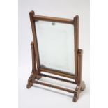 An early 20th century oak rectangular swing dressing table mirror, on shaped end supports joined