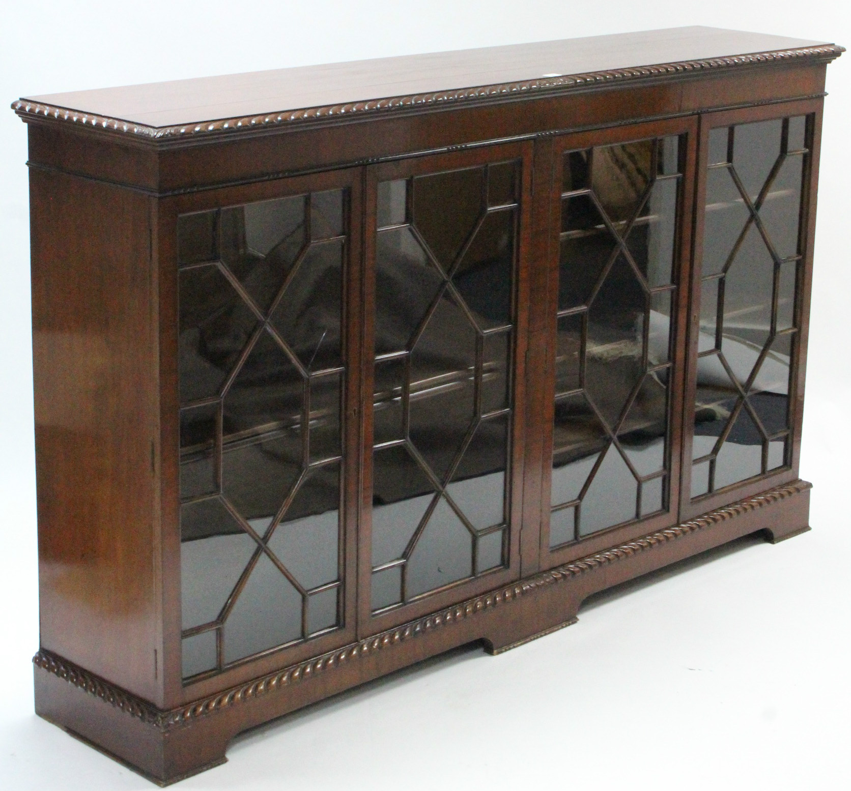 A 19th century-style mahogany bookcase with carved gadrooned edge, with five adjustable shelves