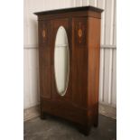 An Edwardian inlaid-mahogany wardrobe enclosed by bevelled oval mirror door to centre above a long