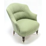 A late Victorian tub-shaped chair upholstered green & ivory geometric material & on short turned