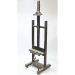 An early 20th century wood studio easel with wind-up handle adjusting the height, maximum height,