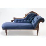 A Victorian carved walnut-frame chaise longue with buttoned back scroll end & sprung seat