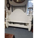 A white painted & carved wooden double bedstead (lacking side rails), 67” wide.