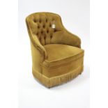 A buttoned-back low easy chair upholstered gold velour, & on short turned legs.