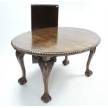 A late 19th century mahogany extending dining table with carved gadrooned edge to the oval top, with