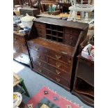 A 19th century oak bureau with fitted interior enclosed by fall-front above an arrangement of