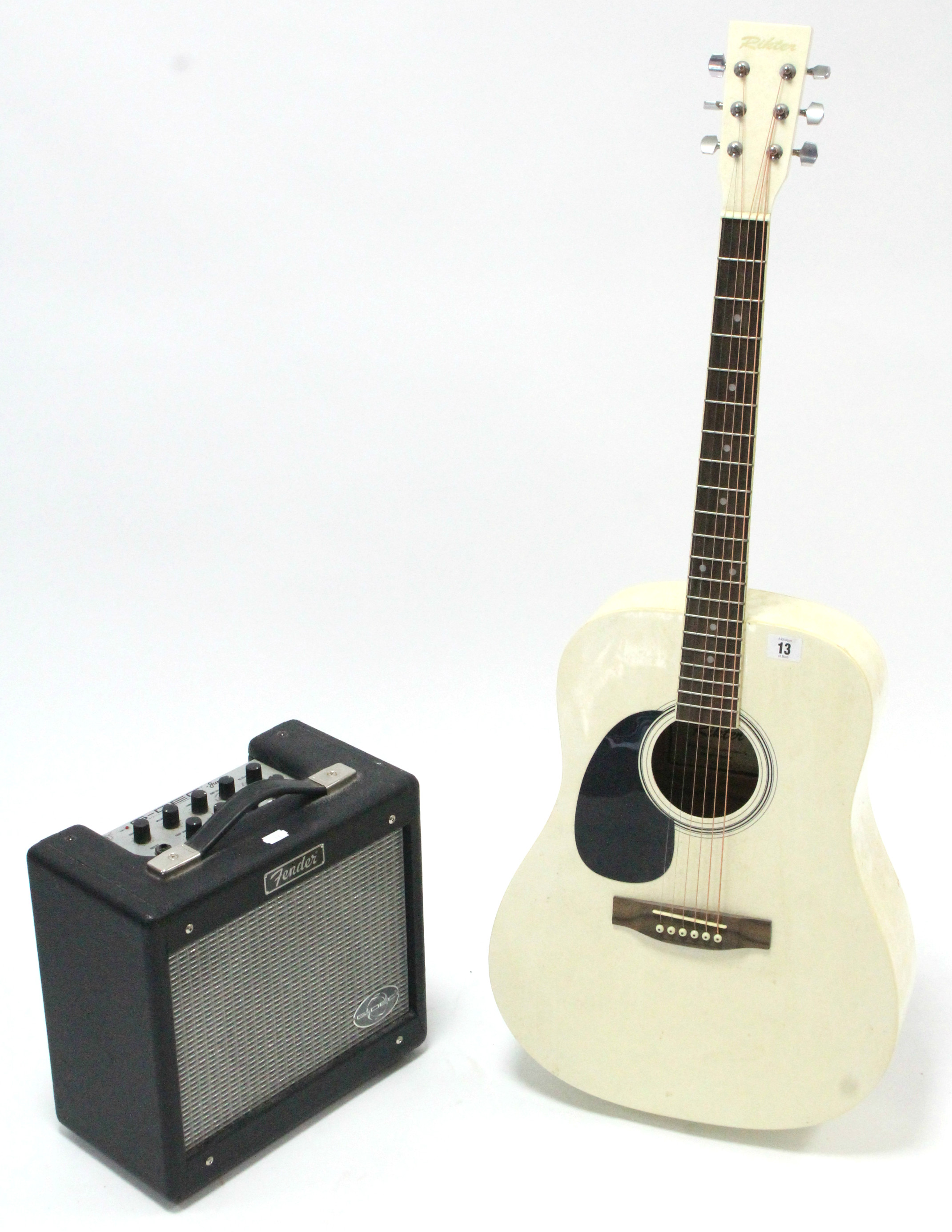 A Rikter six-string acoustic guitar; & a Fender “G-Dec Junior” amplifier.