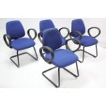 A set of four modern office elbow chairs upholstered blue material.