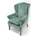 A late 19th/early 20th century wing-back armchair upholstered pale blue velour & on mahogany short