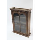 A late 19th/early 20th century pine wall cabinet fitted three shelves enclosed by glazed door, (