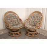 A pair of wicker swivel conservatory chairs, with buttoned loose cushions to the seats & backs.