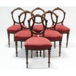 A set of six 19th century carved mahogany balloon-back dining chairs with padded serpentine-front