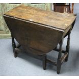 A 19th century oak oval gate-leg dining table on baluster-turned legs & turned feet with plain