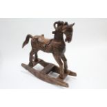 An Eastern-style carved teak child’s rocking horse, 36” high.