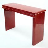 A Chinese-style red lacquered hall table fitted three frieze drawers, & on square end supports,