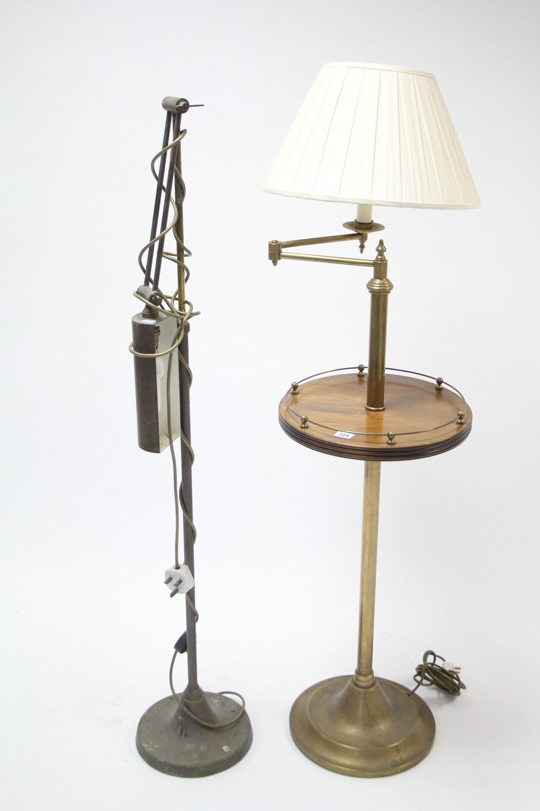 A walnut & brass standard lamp with adjustable single arm & on round pedestal foot, with shade; &