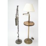 A walnut & brass standard lamp with adjustable single arm & on round pedestal foot, with shade; &