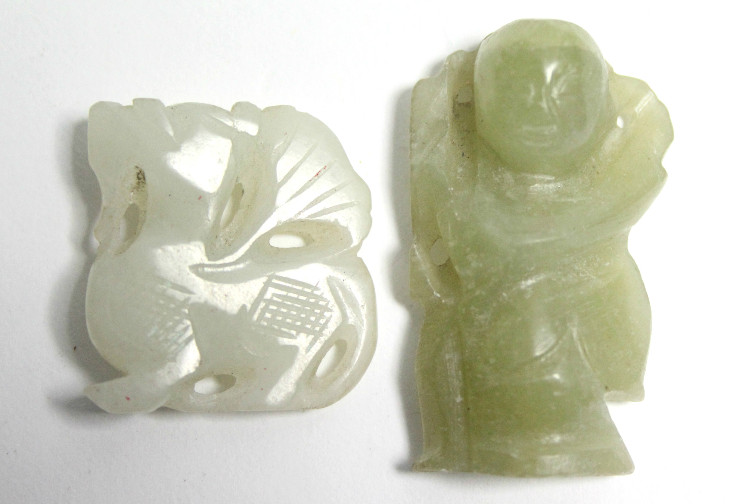 Two carved jade pendants.