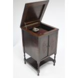 A mid-20th century oak floor-standing gramophone cabinet fitted turntable, enclosed by hinged lift-
