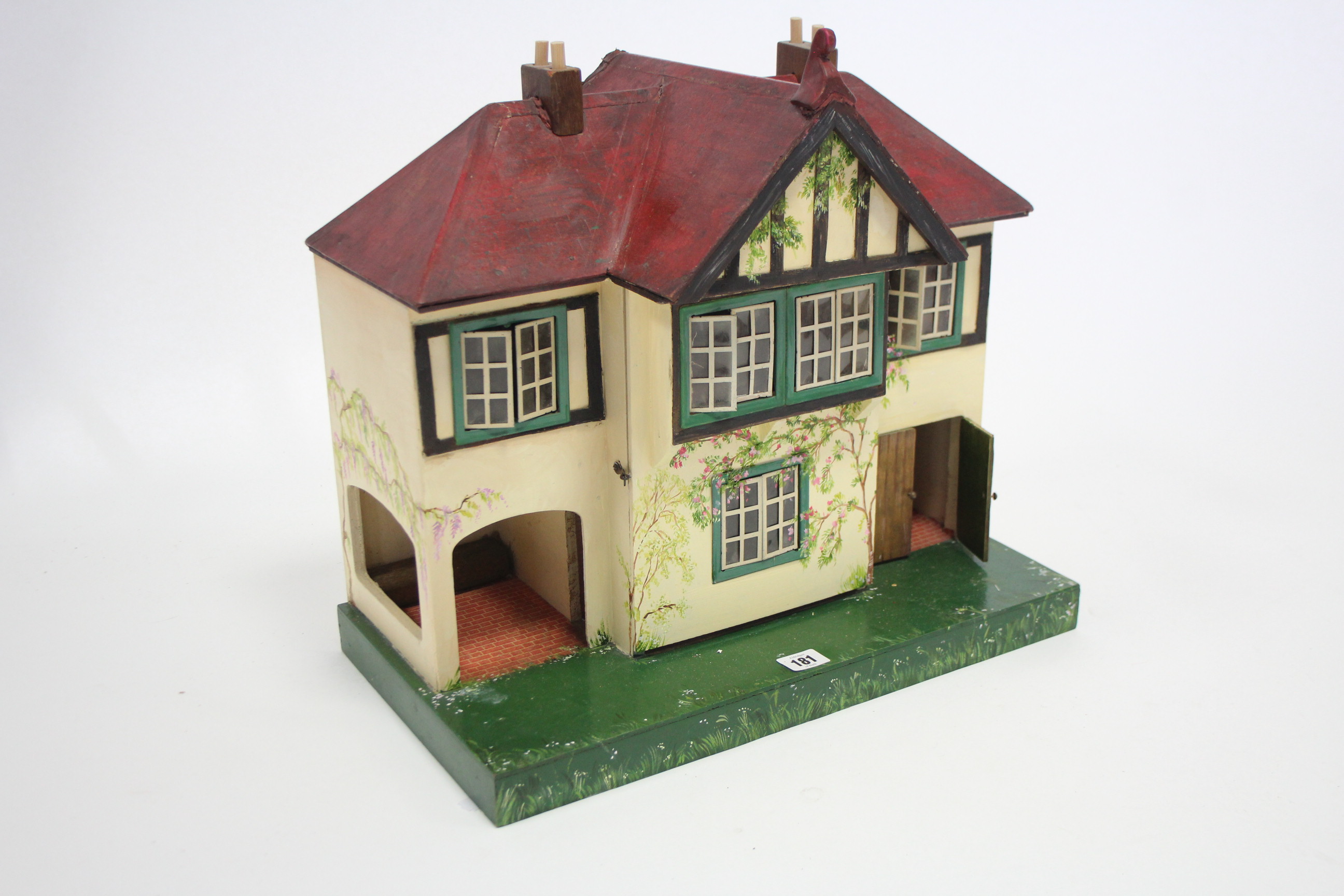 A mid-20th century small painted wooden cottage-style two-storey doll’s house with opening front,