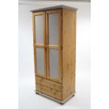 A pale grey painted & natural pine wardrobe, enclosed by pair of panel doors above two long drawers,