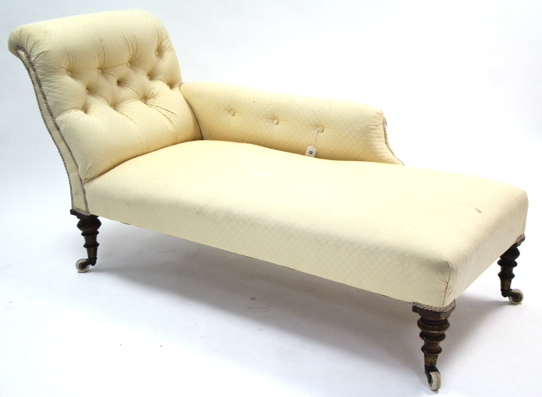 A Victorian chaise longue with buttoned scroll end & sprung seat upholstered pale yellow