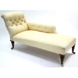 A Victorian chaise longue with buttoned scroll end & sprung seat upholstered pale yellow