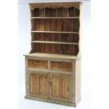 A pine dresser, the upper part with three open shelves & panelled back, the base fitted two frieze