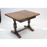 A mid-20th century oak draw-leaf dining table on bulbous-turned end supports with plain stretcher,