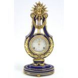 A Franklin Mint “Marie-Antoinette Clock” in blue porcelain case with yellow-metal mounts, 15” high.