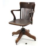 An Edwardian lath-back swivel office chair with padded seat, & on sprung base with four splay legs &