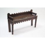 A Victorian carved oak window seat with hard seat, & on bobbin-turned legs, 41” wide.