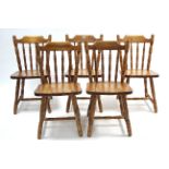 A set of six pine spindle-back kitchen chairs with hard seats & on turned legs with spindle
