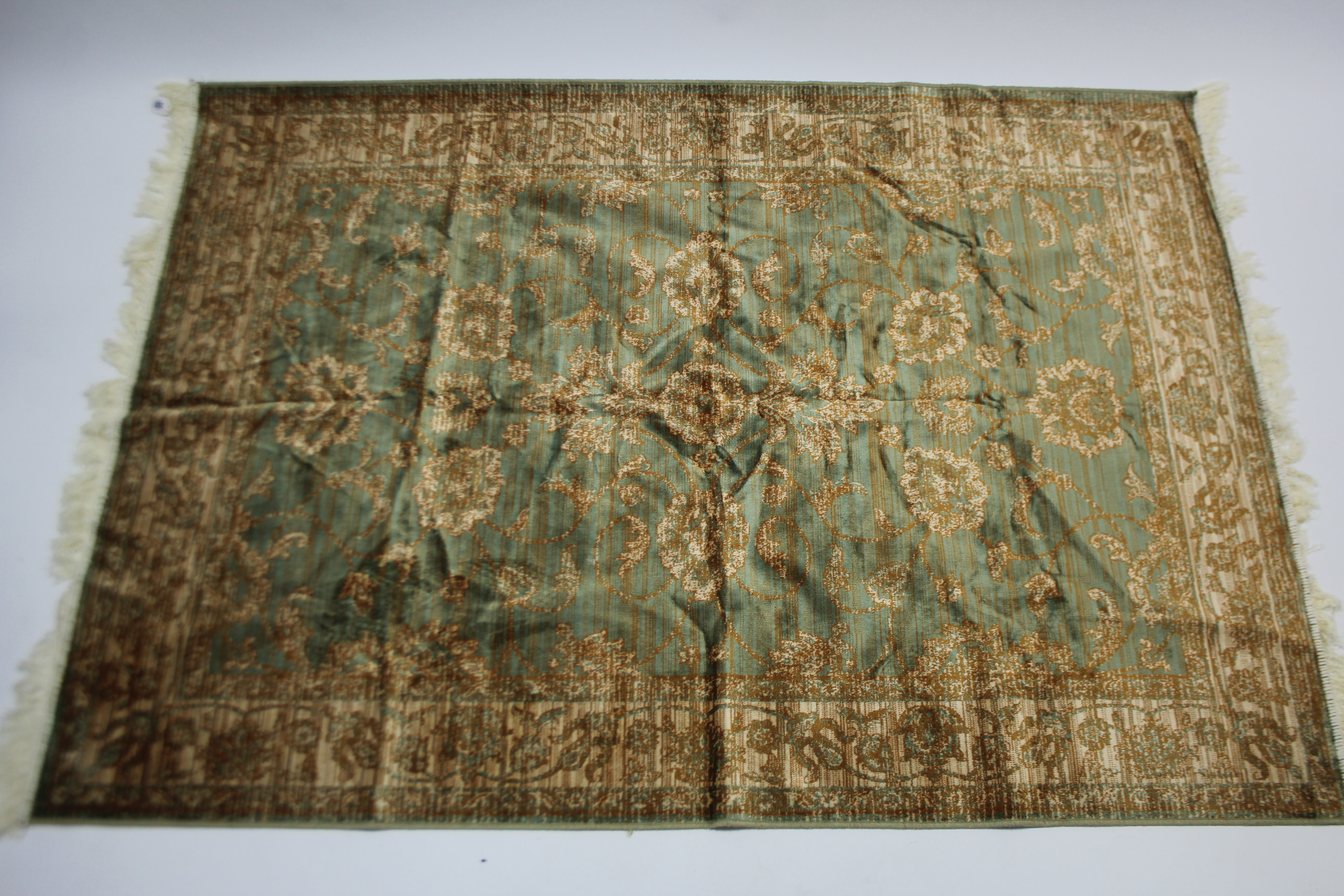 An eastern style rug of green & cream ground with all-over repeating geometric design to centre